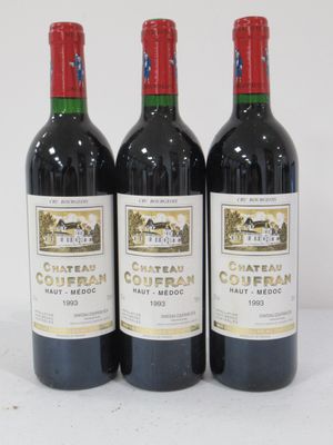 three bottles of red wine are lined up on a white surface