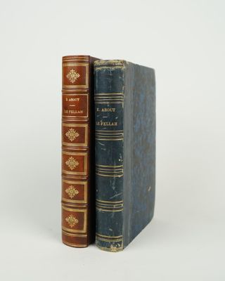 two books are stacked on top of each other on a white surface