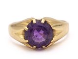 a close up of a gold ring with a purple stone