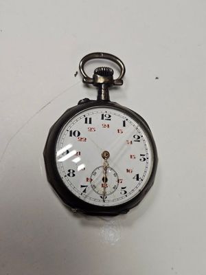 une montre de poche en noir et blanc posée sur une surface blanche