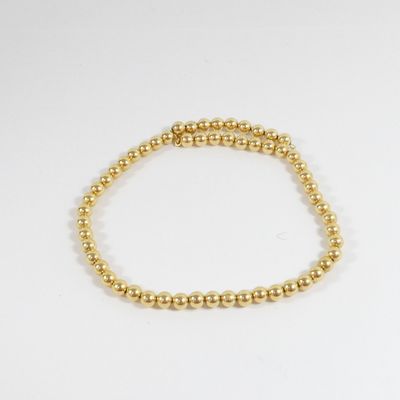 un bracelet orné de perles dorées sur fond blanc