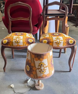 three chairs and a table with a lamp on it