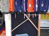 Plusieurs gilets de sauvetage sont suspendus à un porte-gilets dans une pièce