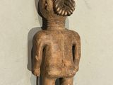 an old wooden figurine of a boy with a haircut