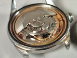 a close up of a watch on a white surface