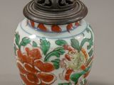 a vase with a lid that has a flower design on it