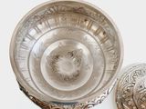 a silver bowl with a lid sitting on a table