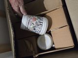 a person pouring something into a cup in a box