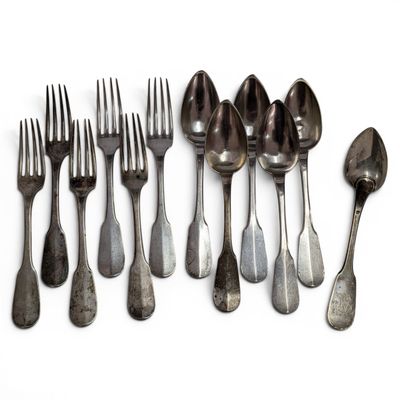 several forks and spoons are arranged in a row on a white surface