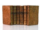 plusieurs vieux livres sont empilés sur une surface blanche
