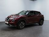 the red nissan suv is parked in a large room
