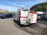 a white truck with a red and white stripe parked in a parking lot