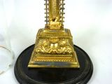 a gold statue of a person on a black base