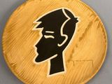 une assiette en bois sur laquelle est dessiné le visage d'un homme