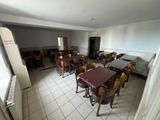 tables and chairs in a room with a refrigerator and a refrigerator freezer