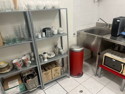 a kitchen with a sink, microwave, and other items on the shelves