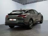 the rear end of a grey car parked in a garage