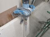 a blue fire hydrant that is attached to a wall