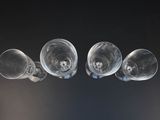 four empty wine glasses sitting on a table