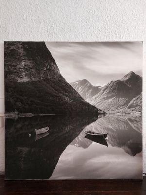 photographie en noir et blanc d'un bateau sur un lac, avec des montagnes en arrière-plan