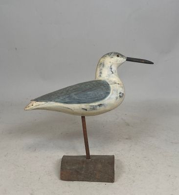 un petit oiseau posé sur un socle en bois