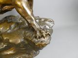 a bronze statue of a dog on a rock
