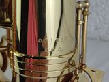 a close up of a gold saxophone with a pink scarf on it