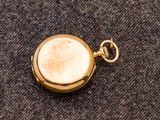 une montre de poche en or avec un cadran blanc