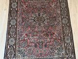 un tapis rouge et noir posé sur un parquet dans une pièce