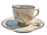 a cup and saucer with a bird design on it