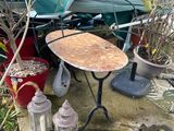 a small table and chairs in the yard next to some potted plants