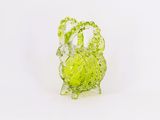 une figurine en verre représentant un chou, posée sur une surface blanche