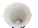 a white and blue vase sitting on a white surface
