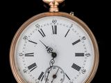 une montre de poche en or avec des chiffres romains sur le cadran