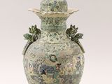 a large vase with a bird on top of it