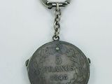 a silver keychain with a coin on it
