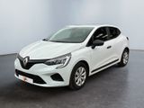 Une voiture blanche est garée dans une pièce au sol noir