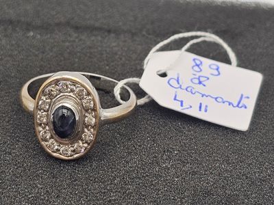 bague en argent et or, sertie d'une pierre noire entourée de diamants blancs