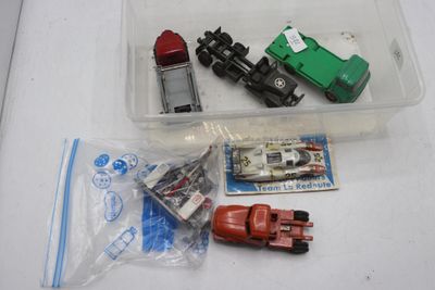 un bac en plastique contenant un petit train et d'autres véhicules miniatures