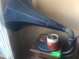 une petite table sur laquelle se trouvent un tourne-disque et une tasse