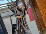 des cuillères, des fourchettes et un sac posés sur une table en verre