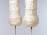 une paire de lanternes en papier blanc posées sur une table blanche