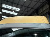 a yellow van parked inside of a building with a roof rack
