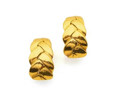 une image d'une paire de boucles d'oreilles en or sur fond blanc