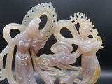 une statue représentant une femme et un dragon sur un fond noir