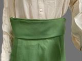 an image of a woman wearing a green skirt and a white shirt