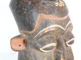 an image of a wooden mask on a white surface with a white background