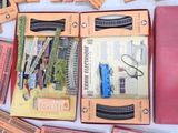 a box of train tracks and a pair of scissors on a table