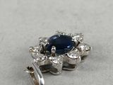 a close up of a blue sapphire and diamond broochle