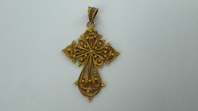pendentif en forme de croix en or sur fond blanc